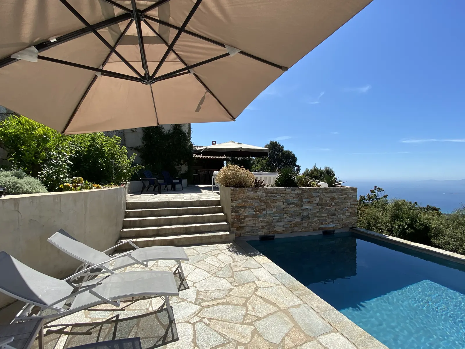 Transats et parasol autour de la piscine