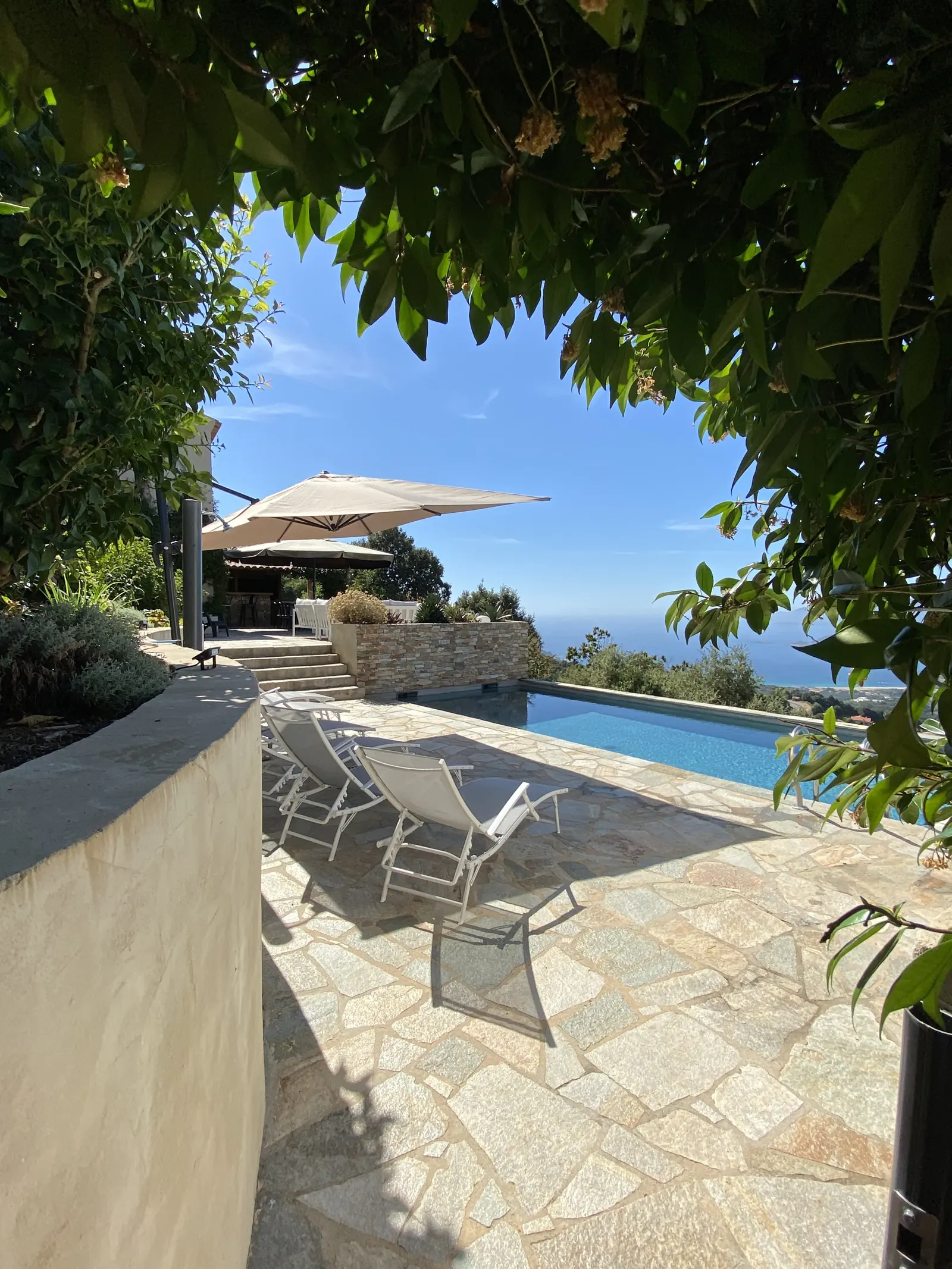 Terrasse ombragée menant à la piscine